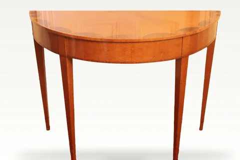 An early 19th century satinwood demi-lune console table